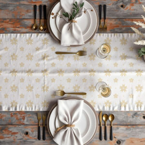 świąteczna aranżacja stołu z białym bieżnikiem w złote gwiazdy