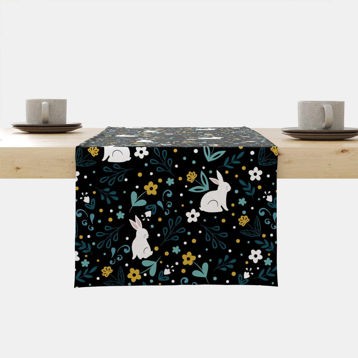Bieżnik rozłożony na stole z czarnym tłem ozdobiony białymi zajączkami i kolorowymi kwiatami