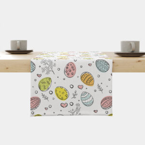 Bieżnik z pastelowymi pisankami rozłożony centralnie na stole widziany z frontu z filiżankami po bokach