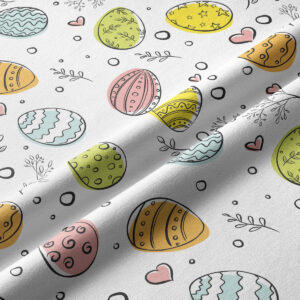 Zbliżenie na fakturę tkaniny i wzór z kolorowymi pisankami oraz delikatnymi gałązkami