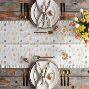 Aranżacja stołu z bieżnikiem: talerze, złote sztućce, serwetki związane gałązkami i wielkanocnymi dekoracjami