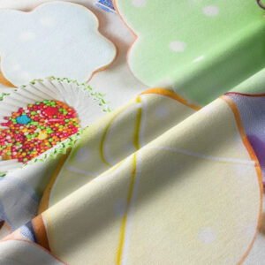 zbliżenie na detal z pastelowymi ciasteczkami, posypką i miękką tkaniną