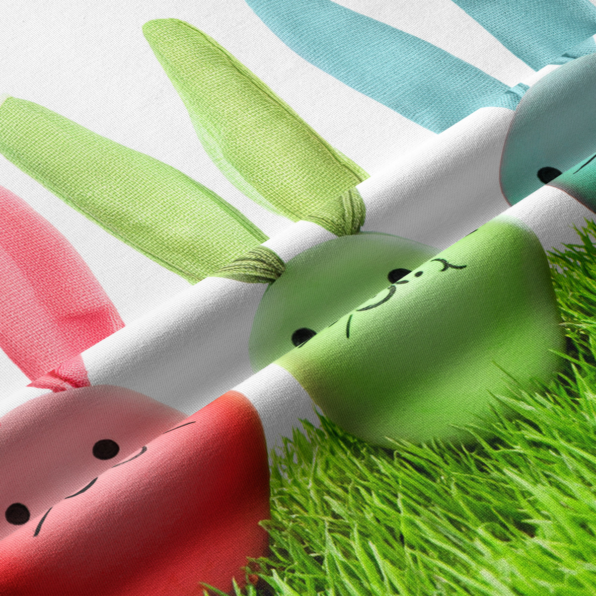 Zbliżenie na fakturę tkaniny i detal pasujących pastelowych jajek z uszami z nadrukiem zajączków na trawie