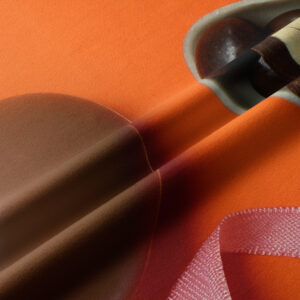 zbliżenie tkaniny bieżnika z detalem czekoladowego jajka i satynowej różowej wstążki