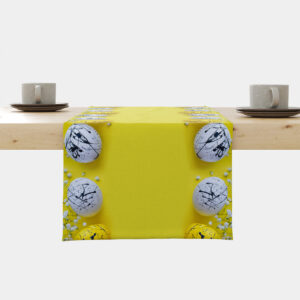 Bieżnik rozłożony na stole z żółtym tłem i białymi pisankami z czarnymi rozbryzgami