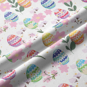 Zbliżenie na detal tkaniny z kolorowymi pisankami i delikatnymi kwiatami