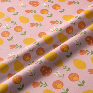 Zbliżenie na fakturę tkaniny i nadruk z żółtymi pisankami oraz pomarańczowymi kwiatami