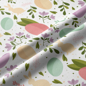 Zbliżenie tkaniny z motywem pisanek, zajączków i drobnych listków w pastelowych kolorach