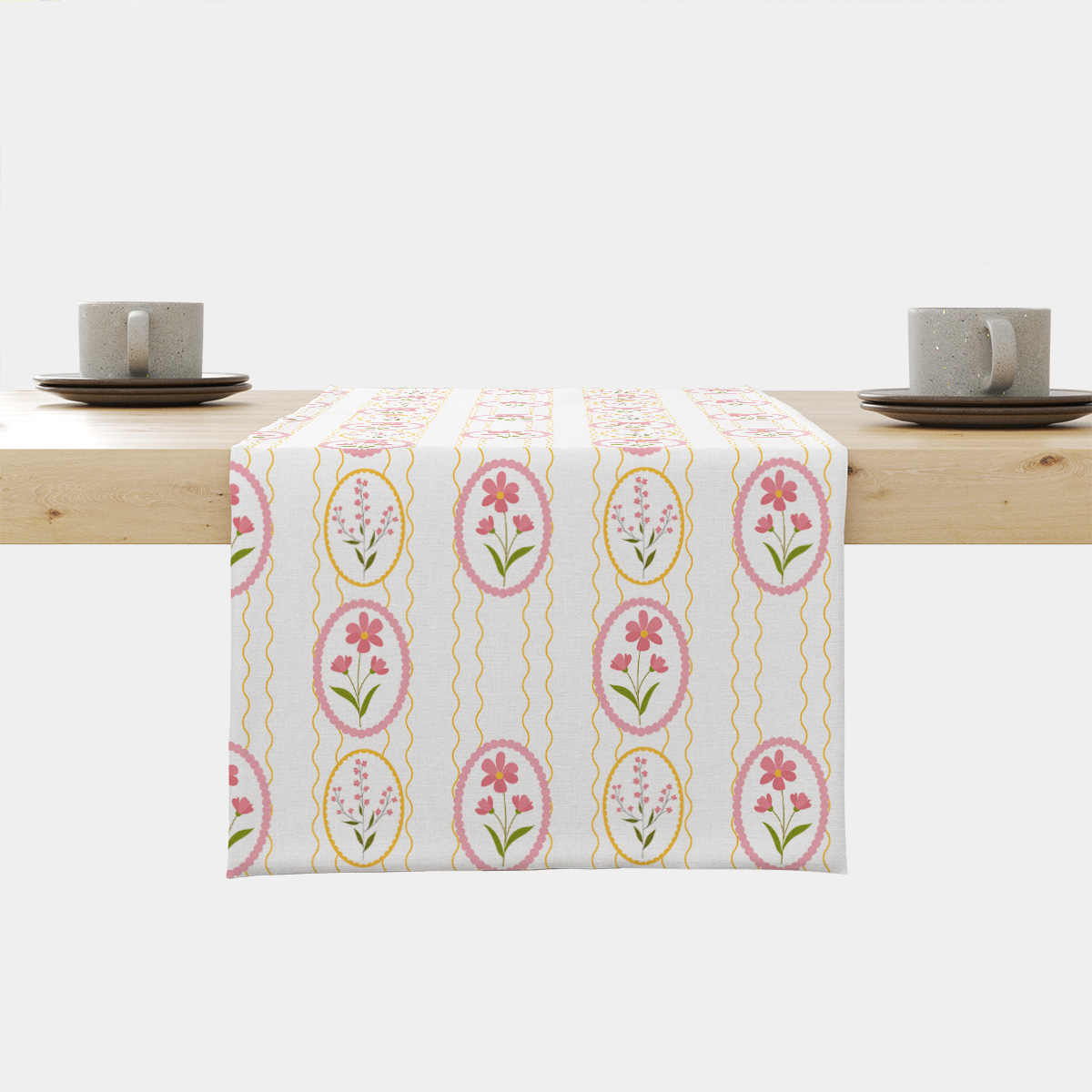 Bieżnik z motywem pastelowych pisanek i różowych kwiatów ułożony na drewnianym stole, widok z przodu
