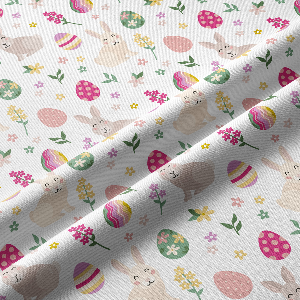 Zbliżenie na tkaninę z motywem króliczków, pisanek i drobnych kwiatów w delikatnych kolorach