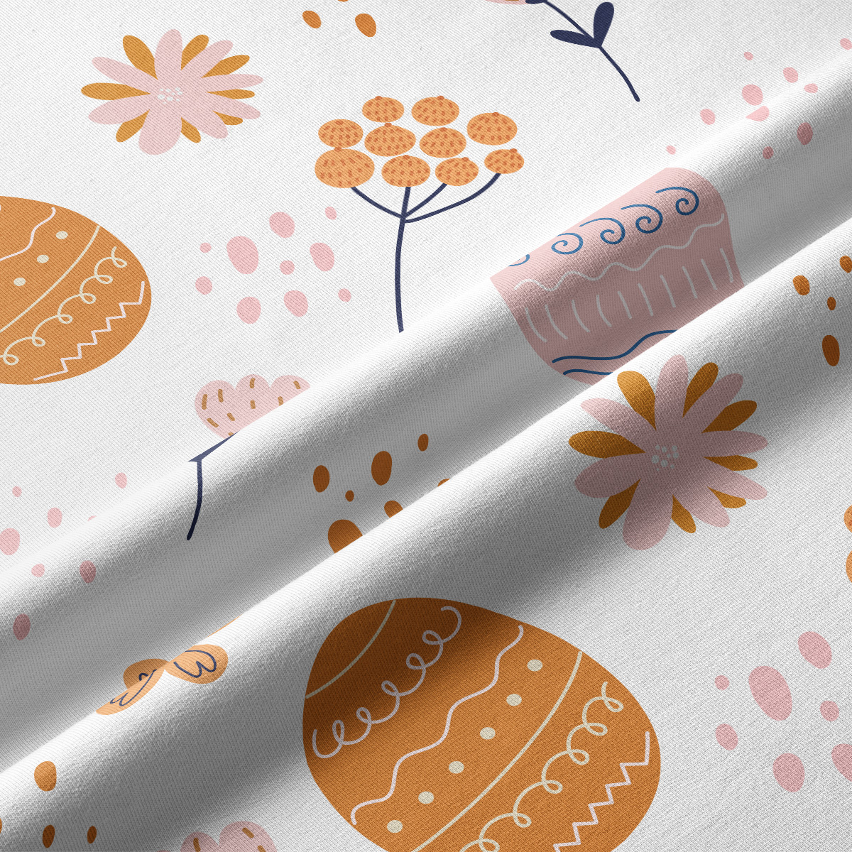 Zbliżenie na tkaninę z motywem pisanek i drobnych kwiatów, widoczna subtelna faktura materiału