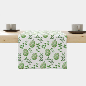 Bieżnik na stole z wzorem zielonych pisanek i zielonych gałązek na jasnym tle