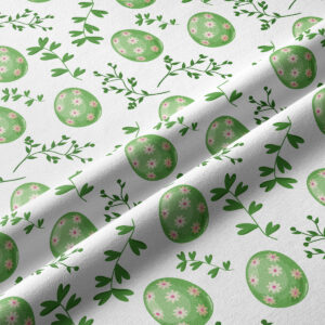 Zbliżenie faktury tkaniny i detali wzoru z zielonymi pisankami i różowymi kwiatuszkami