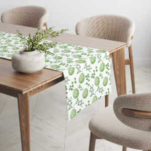 Bieżnik rozłożony na drewnianym stole z wazonem i gałązkami jako dekoracja