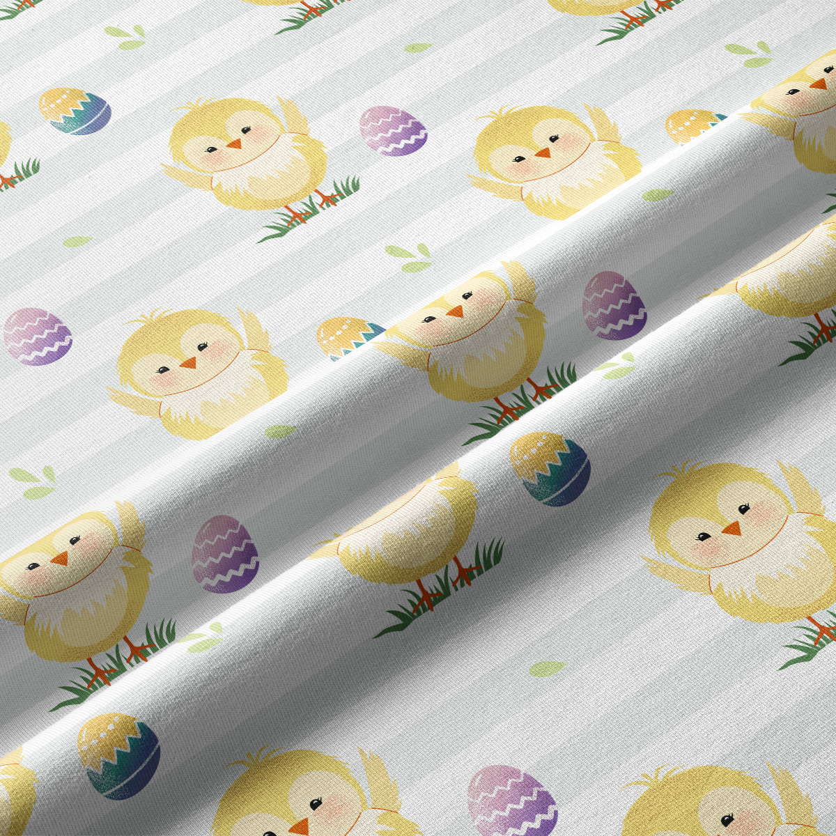 Zbliżenie na tkaninę pokazujące szczegóły rysunku kurczaczków i pastelowych pisanek