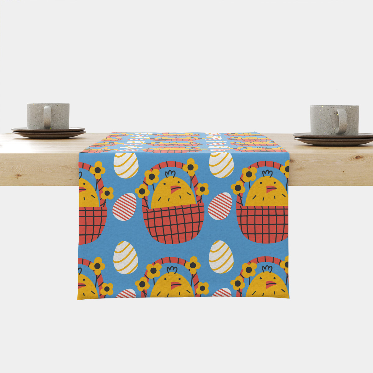 Bieżnik na stole z motywem wielkanocnych kurczaczków w koszykach na niebieskim tle w aranżacji stołu