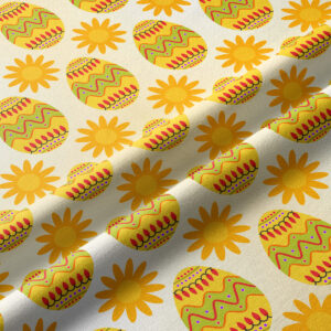 Zbliżenie na fakturę tkaniny i szczegóły kolorowych pisanek oraz słoneczek w nadruku