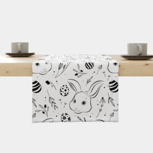 Bieżnik z czarno-białym wzorem wielkanocnym z króliczkami i pisankami ułożony na drewnianym stole