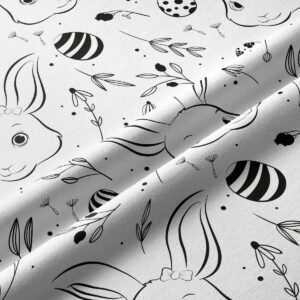 Zbliżenie faktury tkaniny i detali nadruku przedstawiających króliczka i ozdobne pisanki