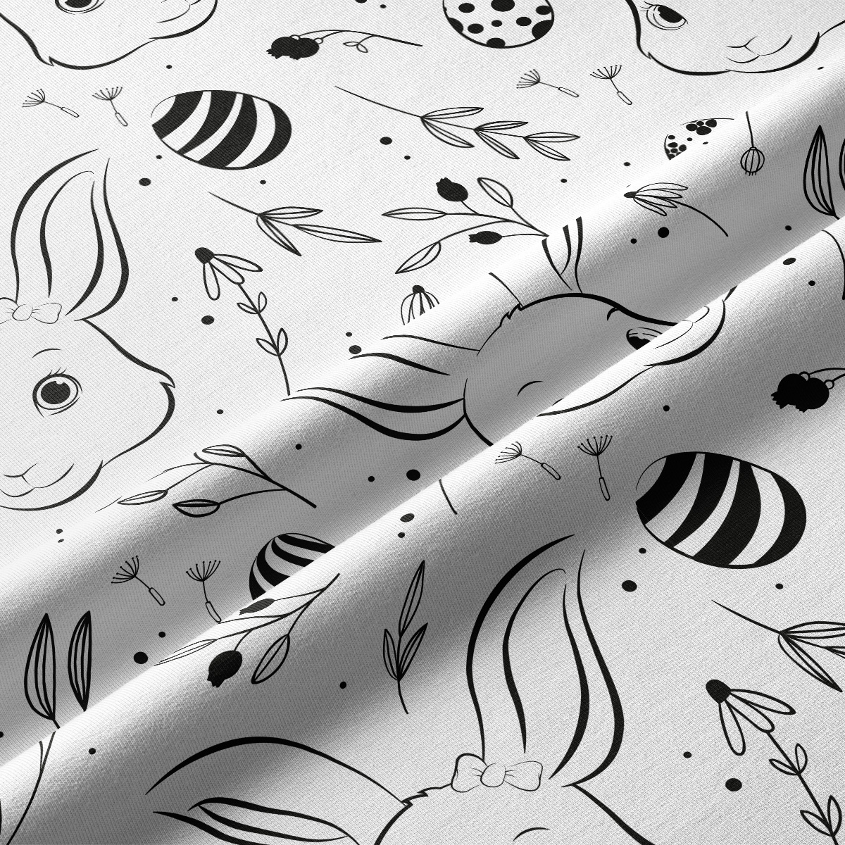 Zbliżenie faktury tkaniny i detali nadruku przedstawiających króliczka i ozdobne pisanki