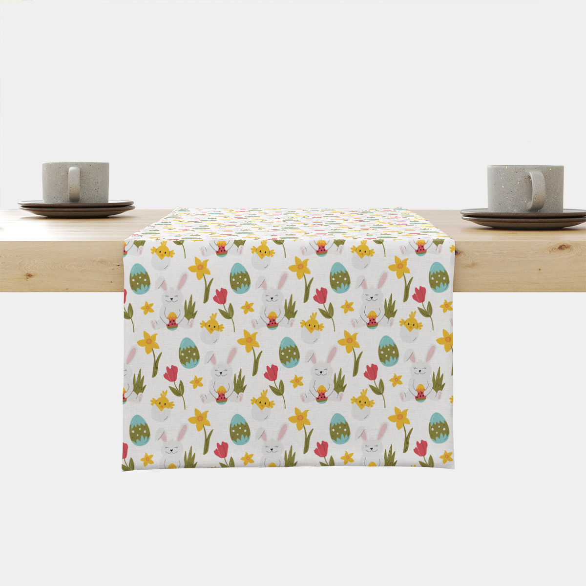 Bieżnik rozłożony na drewnianym stole z motywem zajączków, pisanek i kwiatów widoczny z przodu