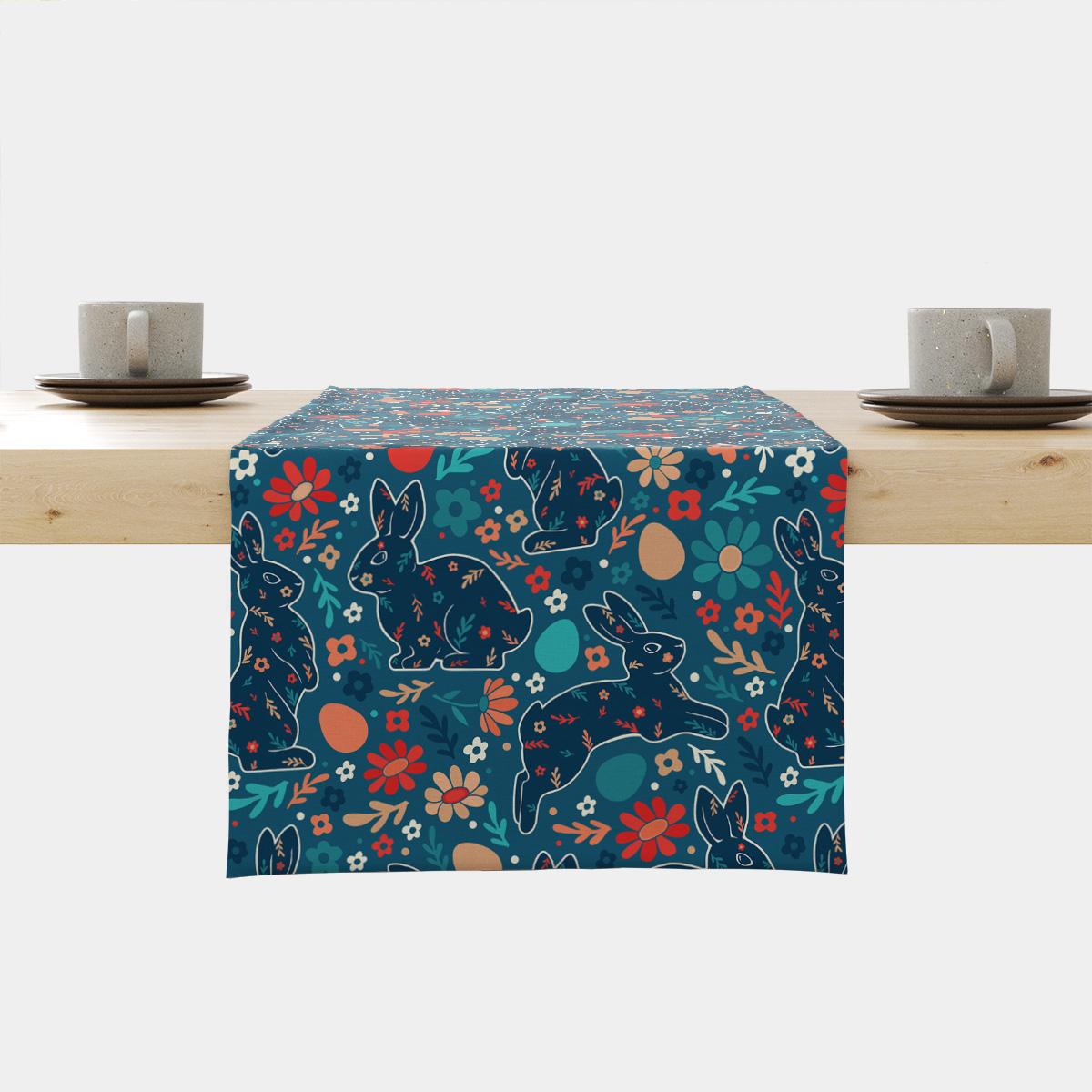 Bieżnik z motywem wielkanocnych zajączków i kolorowych kwiatów ułożony na drewnianym stole, widok z przodu