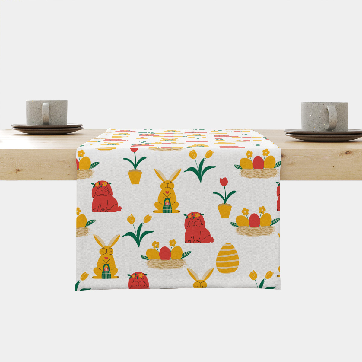 Bieżnik z wiosennym wzorem z zajączkami, pisankami i tulipanami na jasnym tle ułożony na drewnianym stole
