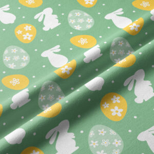 Zbliżenie na fakturę tkaniny i szczegóły wzoru: białe sylwetki zajączków i żółte pisanki