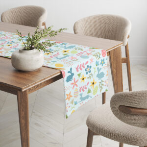 Kąt ujęcia bieżnika na jasnym stole, kolorowe zajączki i delikatne listki tworzą dekoracyjny wzór