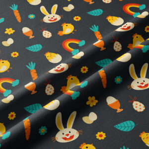 Zbliżenie na tkaninę pokazujące powtarzalny wzór z króliczkami, kurczaczkami, marchewkami i tęczami