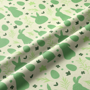 Zbliżenie na fakturę tkaniny i szczegóły wzoru z zajączkami, jajkami i listkami