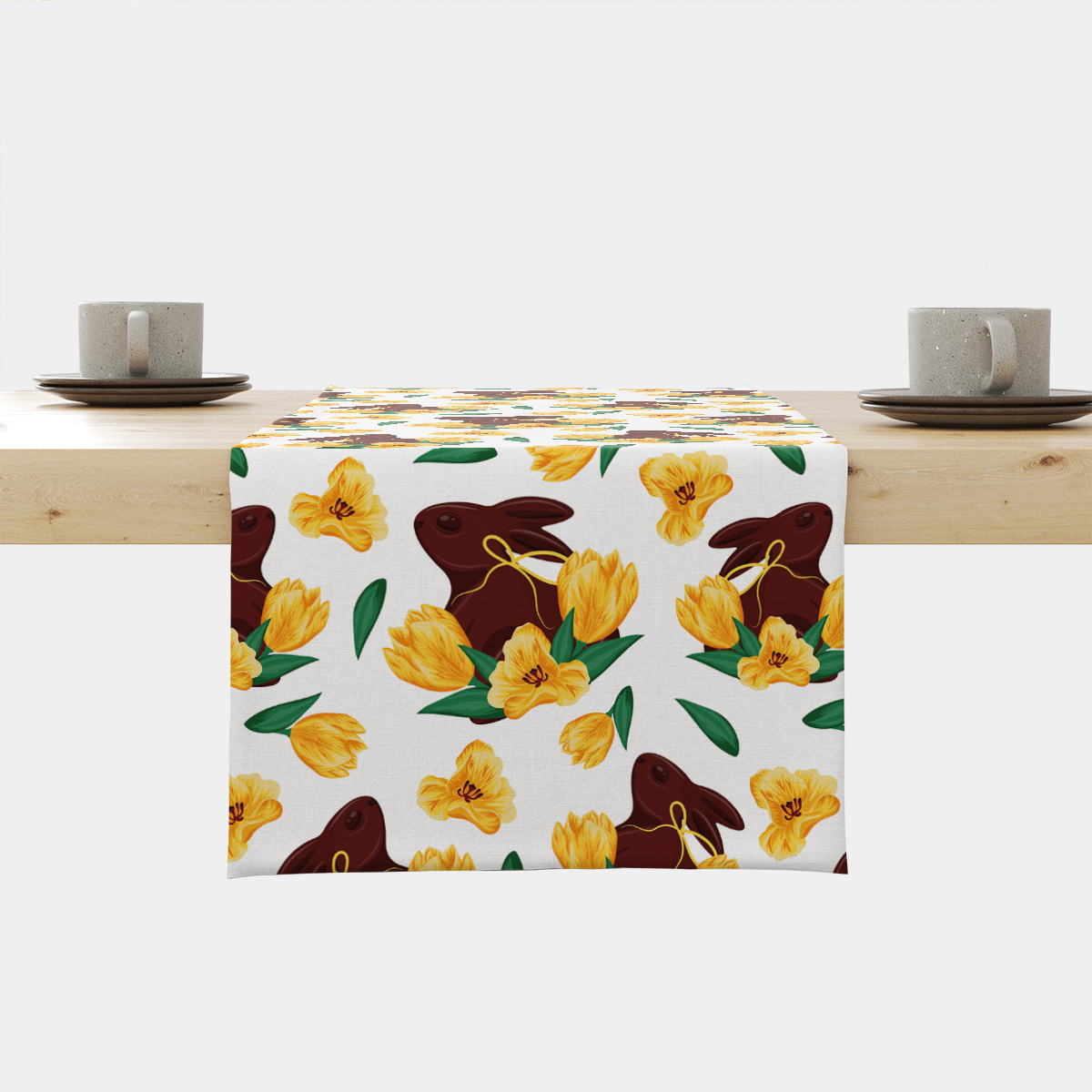 Bieżnik z motywem czekoladowych zajączków i żółtych tulipanów ułożony na drewnianym stole