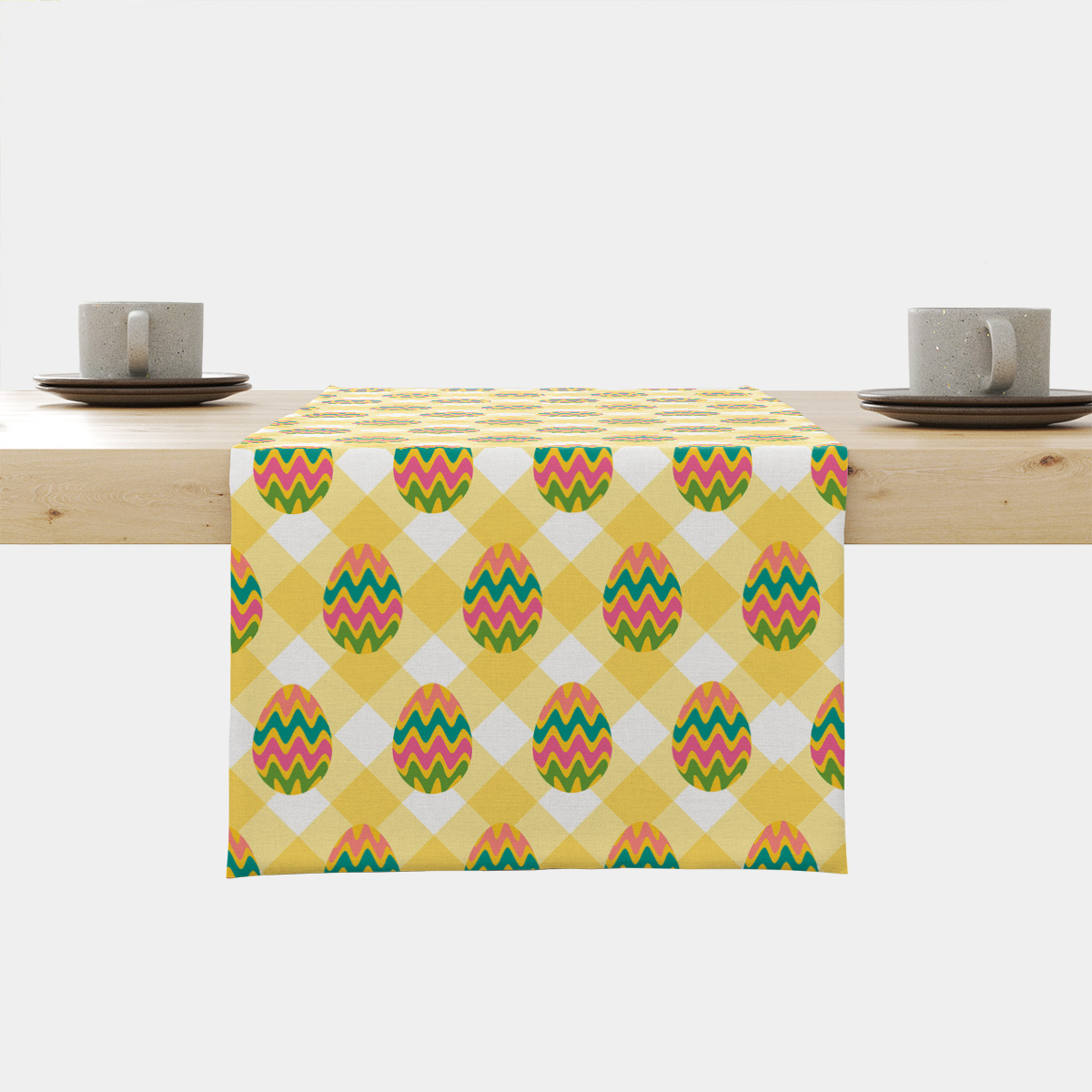 Bieżnik rozłożony na stole z widocznym centralnym fragmentem wzoru: żółta krata z kolorowymi pisankami