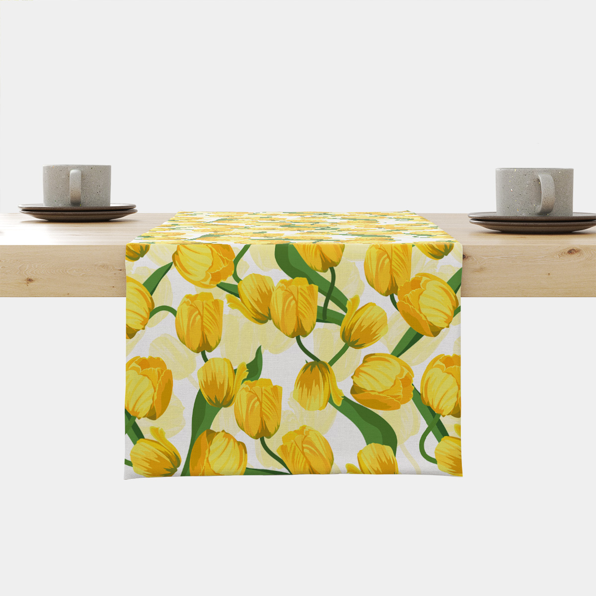 Bieżnik z żółtymi tulipanami na białym tle rozłożony na drewnianym stole, widok z przodu