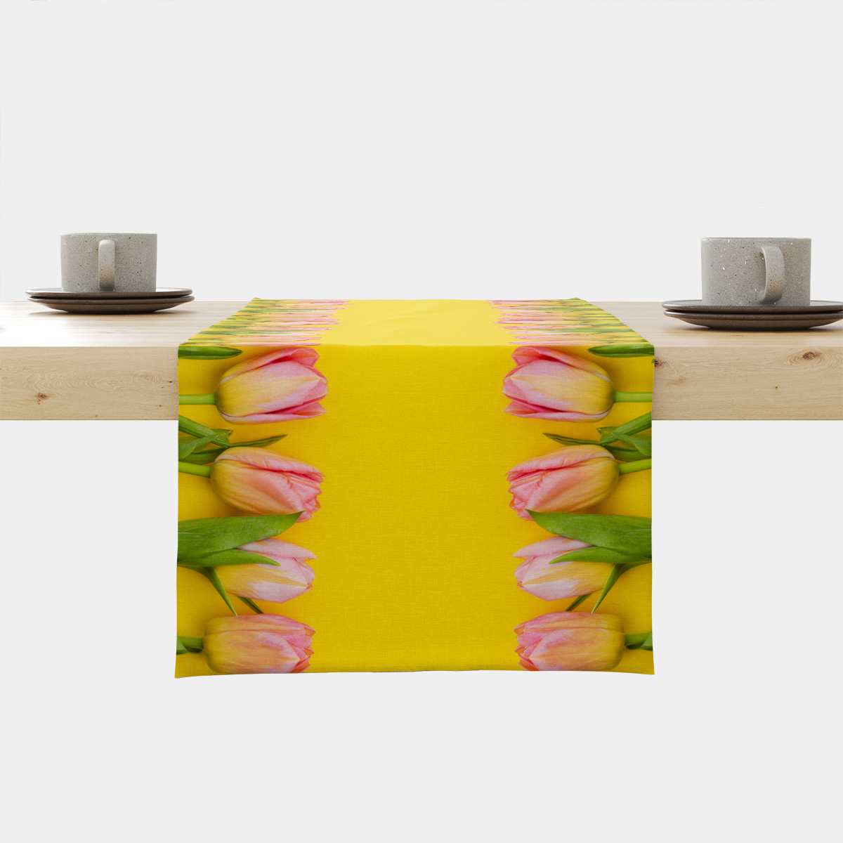 Bieżnik rozłożony na stole z różowymi tulipanami ułożonymi przy krawędziach na żółtym tle