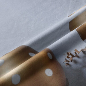 Zbliżenie na tkaninę pokazujące złote jajka i punktowany wzór oraz fakturę materiału