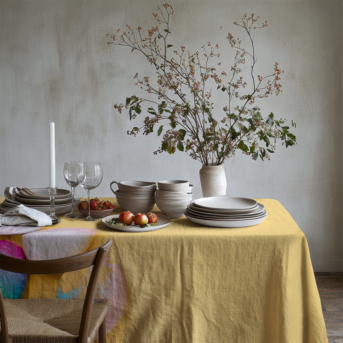 Rustykalna scena nakrytego stołu z ceramicznymi naczyniami na żółtym obrusie z motywem pisanek