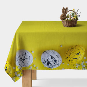 obrus w limonkowym odcieniu z dekoracyjnym pasem malowanych pisanek i koszykiem wielkanocnym na rogu stołu