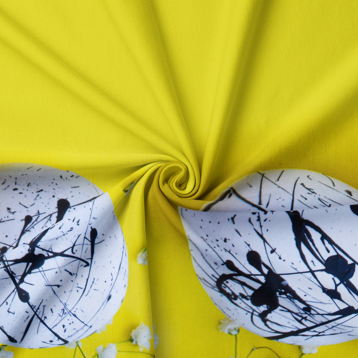 zbliżenie na tkaninę i dwa białe pisanki z czarnymi, abstrakcyjnymi plamami na limonkowym tle