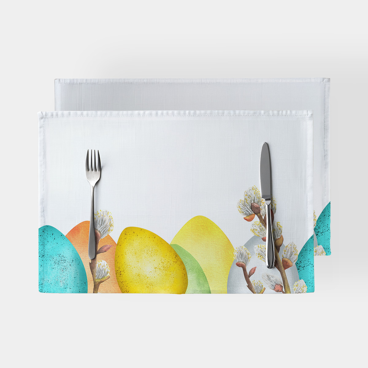 biała podkładka stołowa z kolorowymi pisankami i gałązkami bazi na dolnym rancie oraz sztućcami