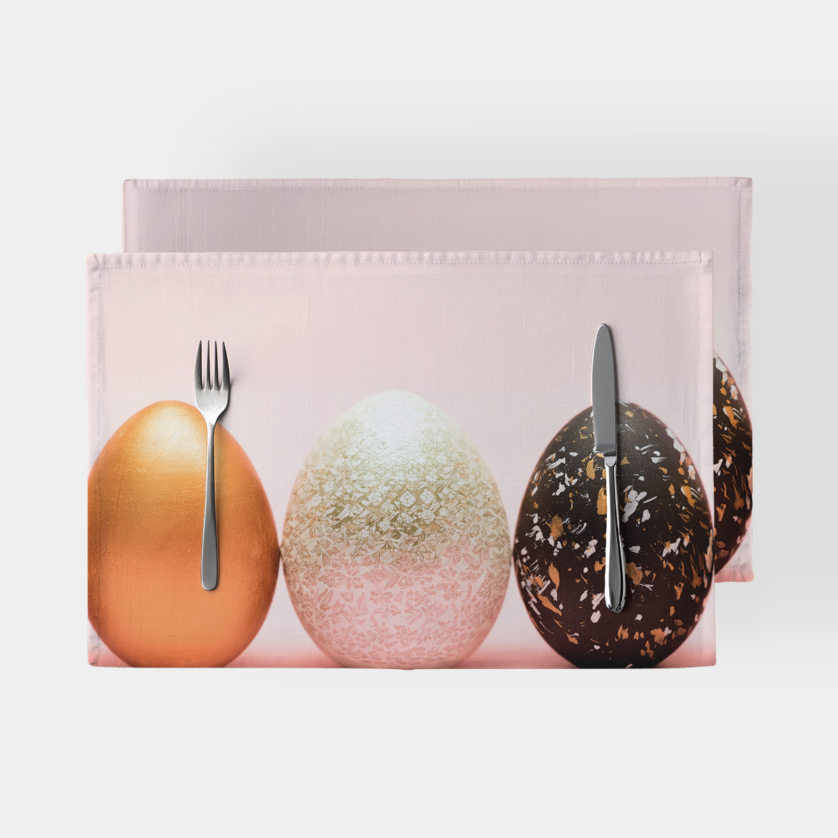 Podkładka z trzema ozdobnymi pisankami na jasnoróżowym tle, widok z przodu