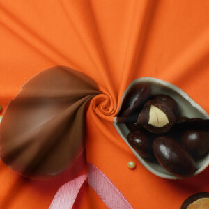 zbliżenie na detal obrusu z czekoladowymi kulkami w miseczce oraz miękką fakturą tkaniny