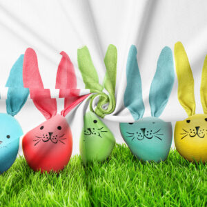 Zbliżenie na fakturę tkaniny i szczegóły nadruku z kolorowymi zajączkami i trawiastym motywem