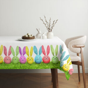 Aranżacja stołu z wazą, gniazdem z jajkami i dekoracjami na obrusie z pisankami