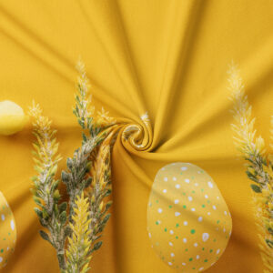 zbliżenie na tkaninę i wzór: żółte pisanki w kropki oraz zielone kłosy na musztardowym tle