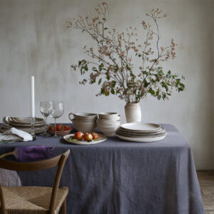 Rustykalna aranżacja stołu z ceramiką na grafitowym obrusie ozdobionym tulipanami i pastelowymi jajkami