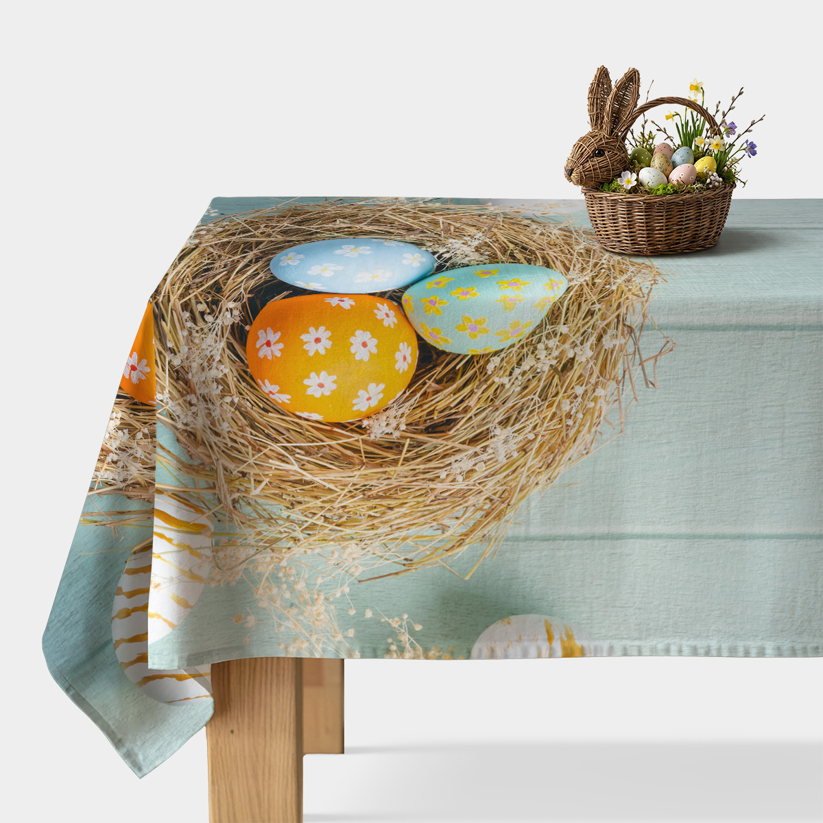 główny widok obrus z gniazdem i trzema kolorowymi pisankami rozłożony na stole