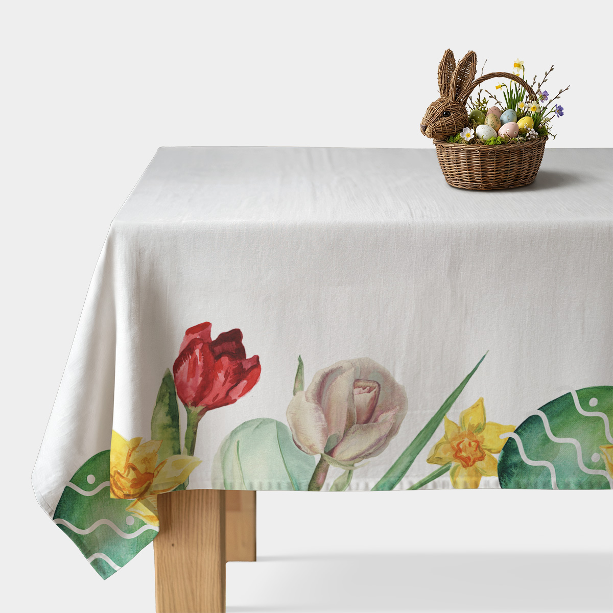 obrus na stole z białym tłem i akwarelowym brzegiem tulipanów oraz ozdobnymi pisankami