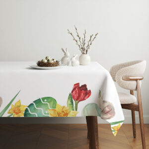 aranżacja stołu z obrusem, wiklinowym koszykiem z pisankami i gałązkami bazi