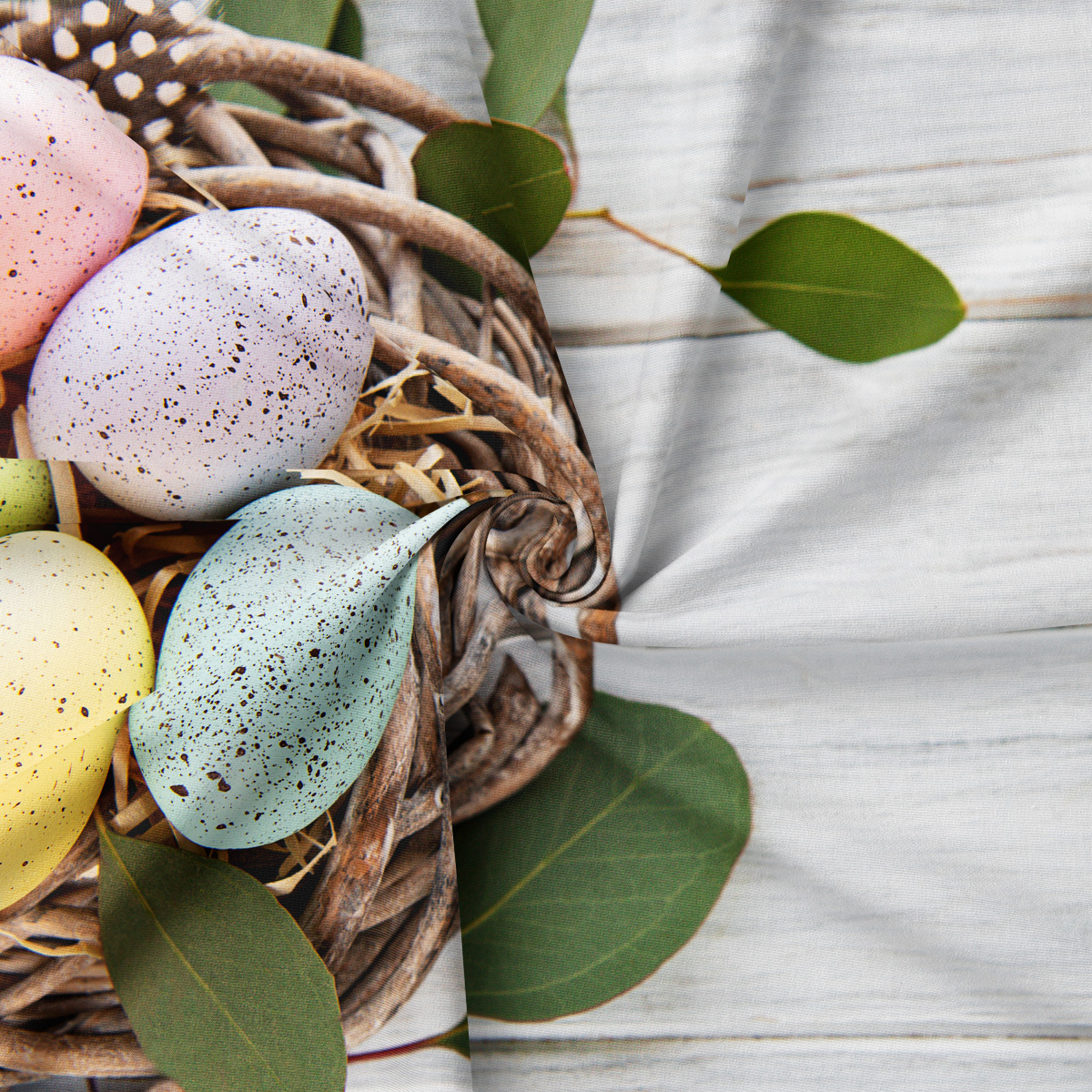 Zbliżenie na złożony obrus pokazujące nadruk pisanek, wikliny i liści